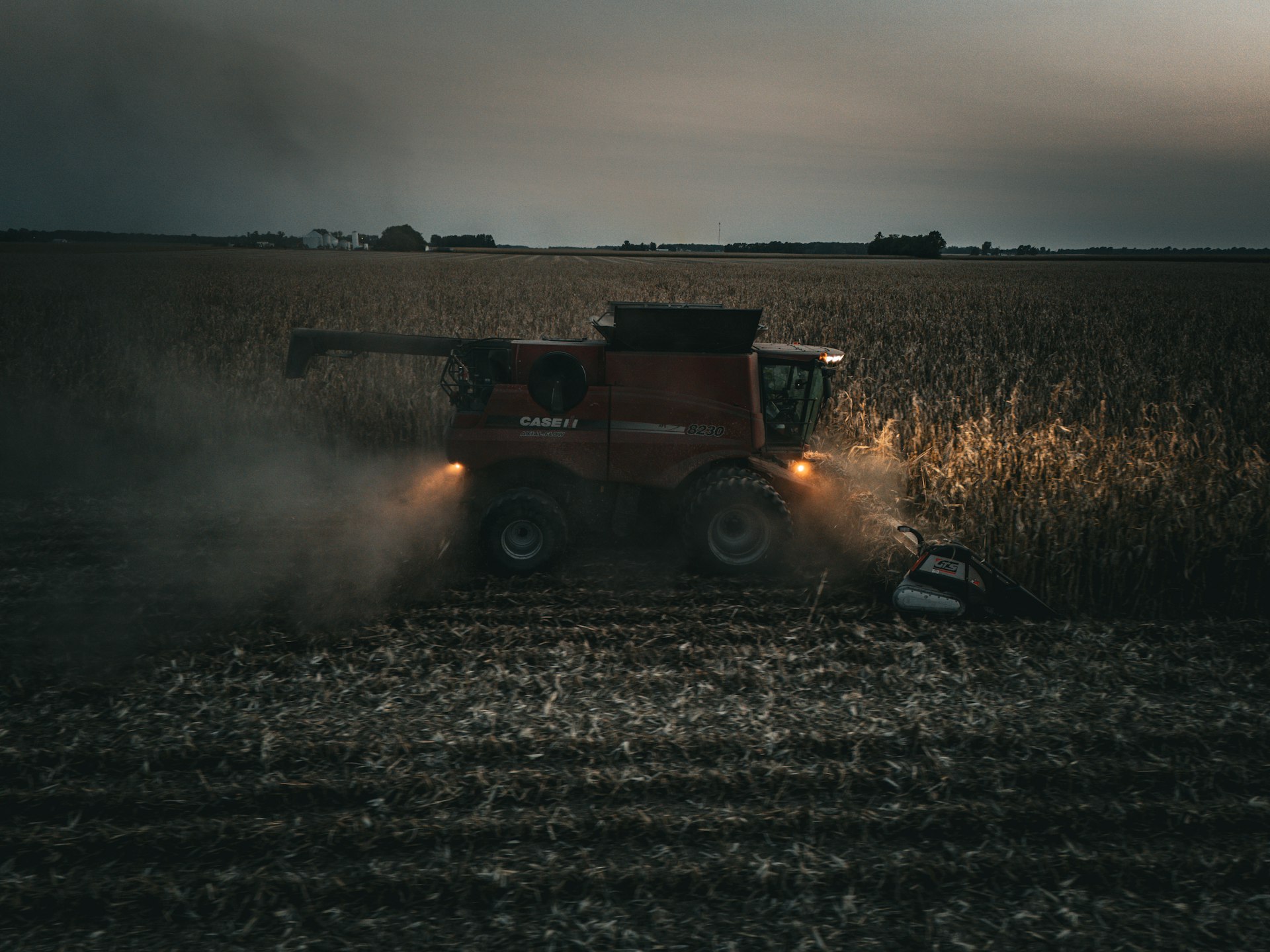 A red tractor is driving through a field